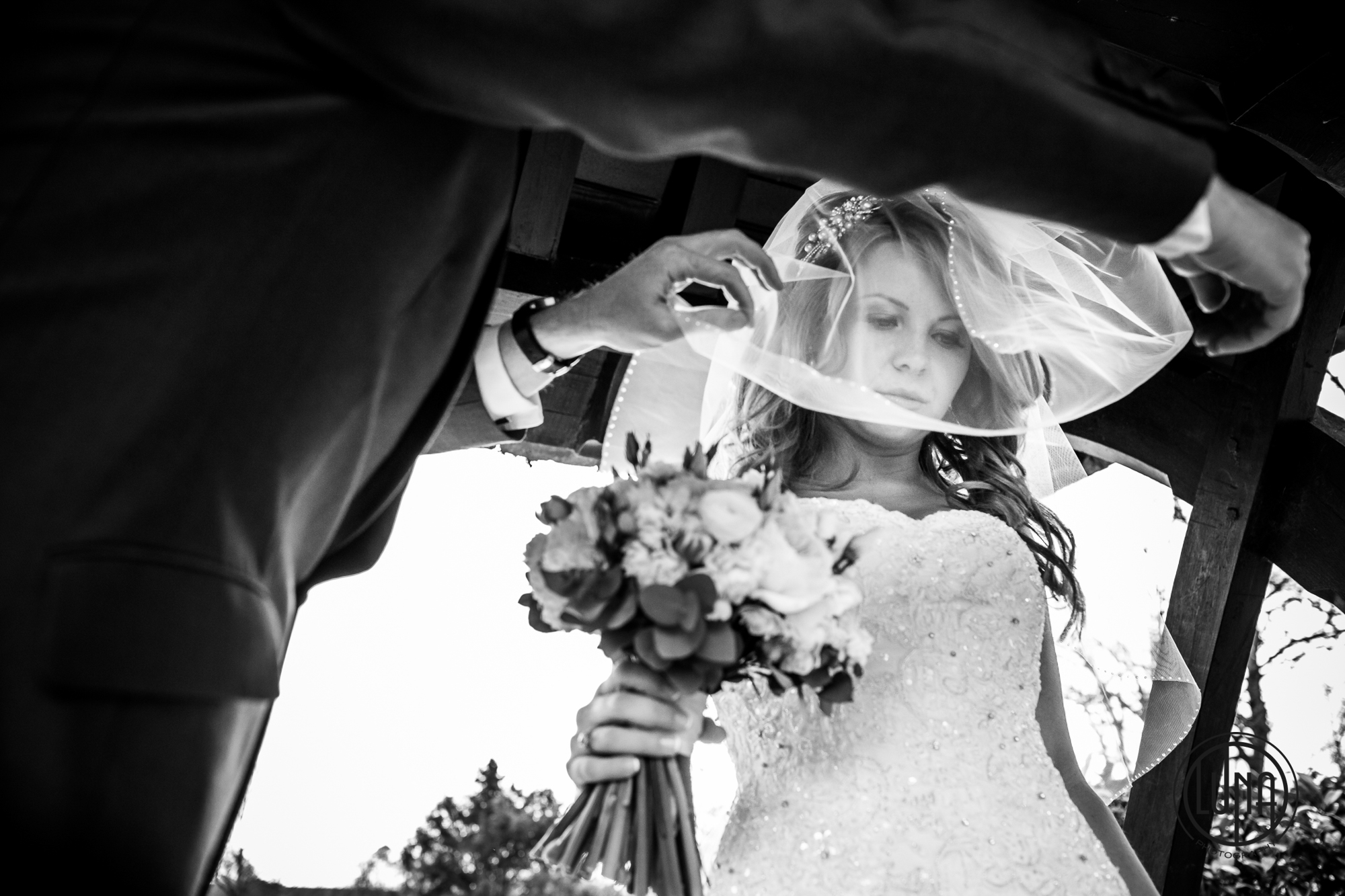 putting veil over brides face ahead of church wedding